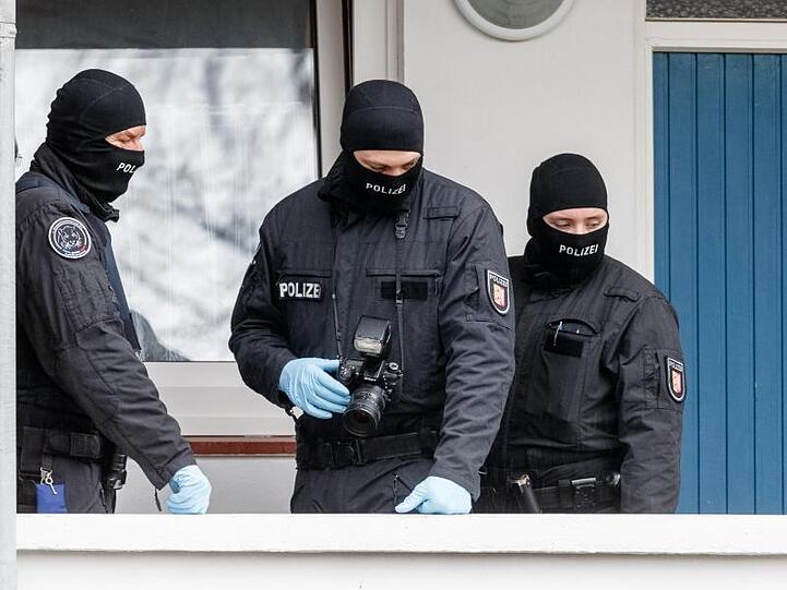 SEK-Beamte stehen während einer Razzia vor einer Wohnung in Bad Segeberg.