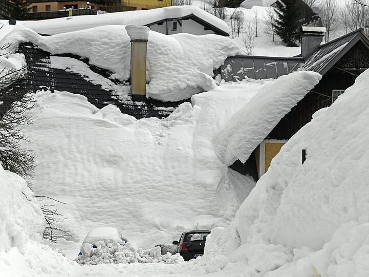 Weiße Wand: Von den Dächern gerutschter Schnee hat im österreichischen Ort Lackenhof Autos und Hauseingänge unter sich begraben.