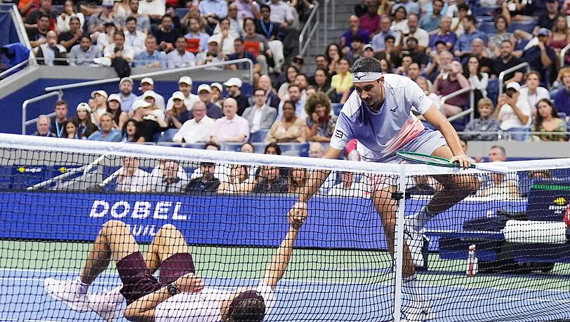 Lorenzo Sonego (r) hilft Zverev nach einem Strauchler wieder auf die Beine.