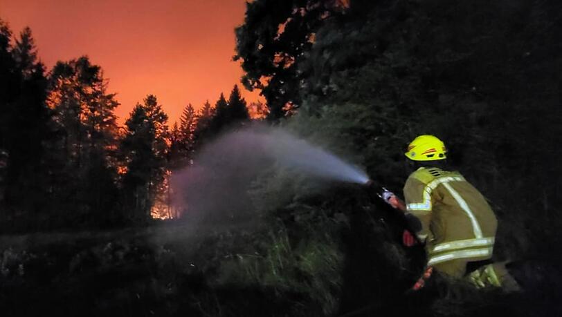 Ein Feuerwehrmann im Einsatz  beim Waldbrand am Chiemsee.