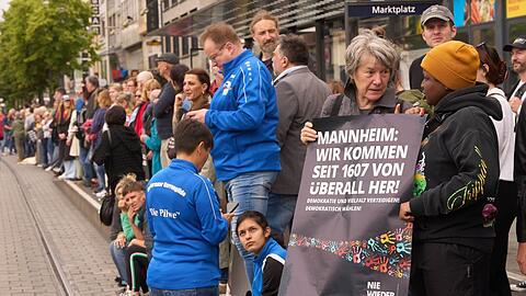 Bürgerinnen und Bürger demonstrieren in Mannheim mit einer Menschenkette gegen Gewalt, Hass und Hetze.