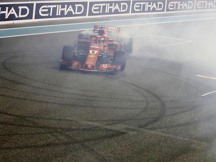 Sebastian Vettel malt mit seinen durchdrehenden Rädern Kreise auf den Asphalt (Donuts).