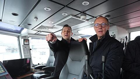 Unionskanzlerkandidat Friedrich Merz lässt sich vom Inhaber des Hamburger Unternehmens VB Group beim Besuch des Feuerlöschboots "Prag" den Hamburger Hafen zeigen.