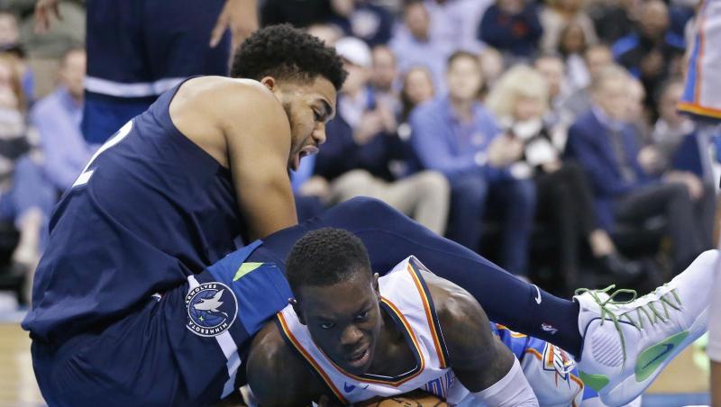 OKC-Spieler Dennis Schröder (r) kommt bei einer Attacke von Minnesotas Karl-Anthony Towns zu Fall. OKC-Spieler Dennis Schröder (r) kommt bei einer Attacke von Minnesotas Karl-Anthony Towns zu Fall.