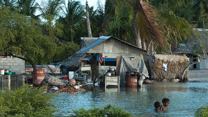 Inselnationen, wie Kiribati, werden durch den steigenden Meeresspiegel überflutet. Inselnationen, wie Kiribati, werden durch den steigenden Meeresspiegel überflutet.
