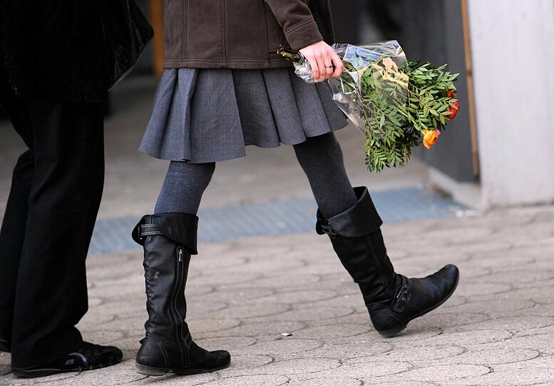 Mit einem Blumenstrauß im Gedenken an Chiara und Sharon betritt diese Frau die Pfarrkirche St. Elisabeth in Planegg. Hier fand der Trauergottesdienst für Chiara und Sharon statt.