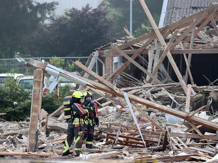 Feuerwehrleute stehen in den Trümmern einer Halle nach einer Explosion in Günzburg. Foto: Mario Obeser/dpa/Archivbild