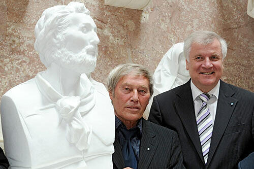 Der Bildhauer Bert Gerresheim (l) und Bayerns Ministerpräsident Horst Seehofer (CSU) stehen am Mittwoch (28.07.2010) in der Walhalla in Donaustauf (Oberpfalz) neben der Büste des Dichters Heinrich Heine.