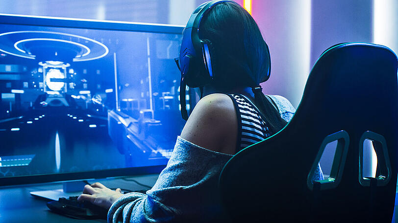Eine junge Dame vor ihrem Gaming-Setup (Symbolbild).