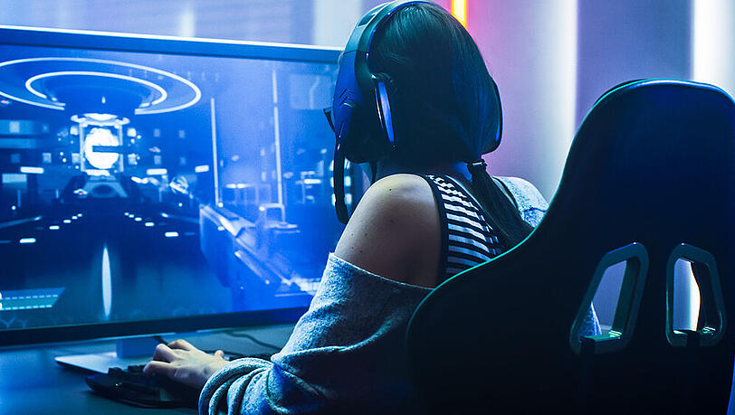 Eine junge Dame vor ihrem Gaming-Setup (Symbolbild). Eine junge Dame vor ihrem Gaming-Setup (Symbolbild).