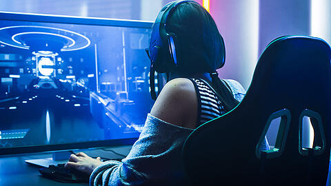 Eine junge Dame vor ihrem Gaming-Setup (Symbolbild).