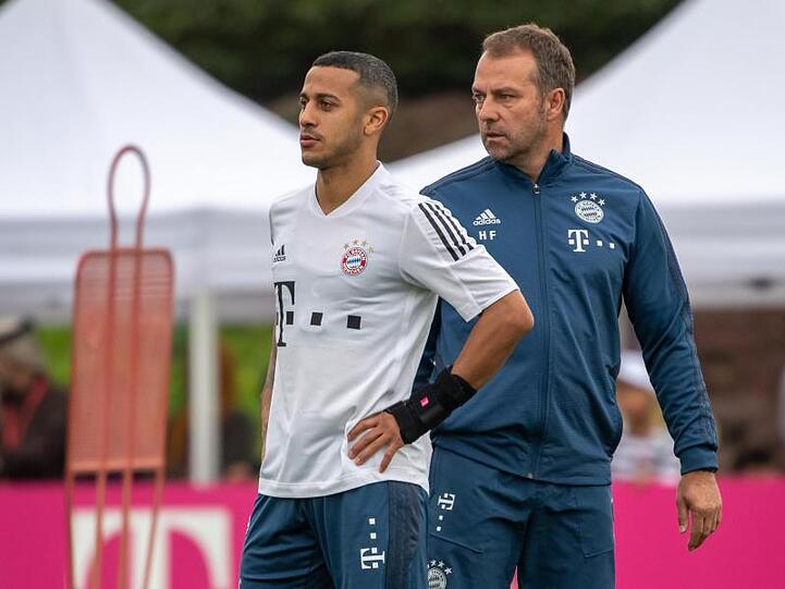 Bayerns Spieler Thiago (l) mit Trainer Hansi Flick auf dem Trainingsgelände des FC Bayern München. Foto: Peter Kneffel/dpa/Archivbild