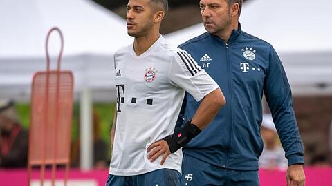 Bayerns Spieler Thiago (l) mit Trainer Hansi Flick auf dem Trainingsgelände des FC Bayern München. Foto: Peter Kneffel/dpa/Archivbild