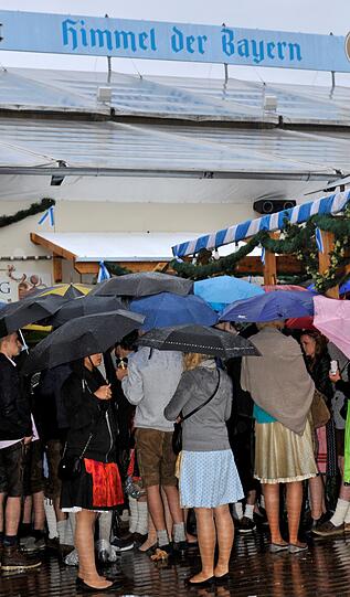 Trotz Sauwetter und Regen warten bereits viele Wiesngänger auf den Wiesnanstich. Der Kampf um den Platz im Bierzelt beginnt schon am frühen Morgen. Die ersten Bilder.