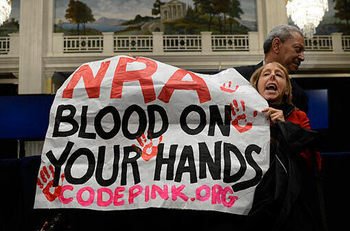 "Blut an euren Händen" - eine Frau demonstriert gegen die US-Waffenlobby NRA.