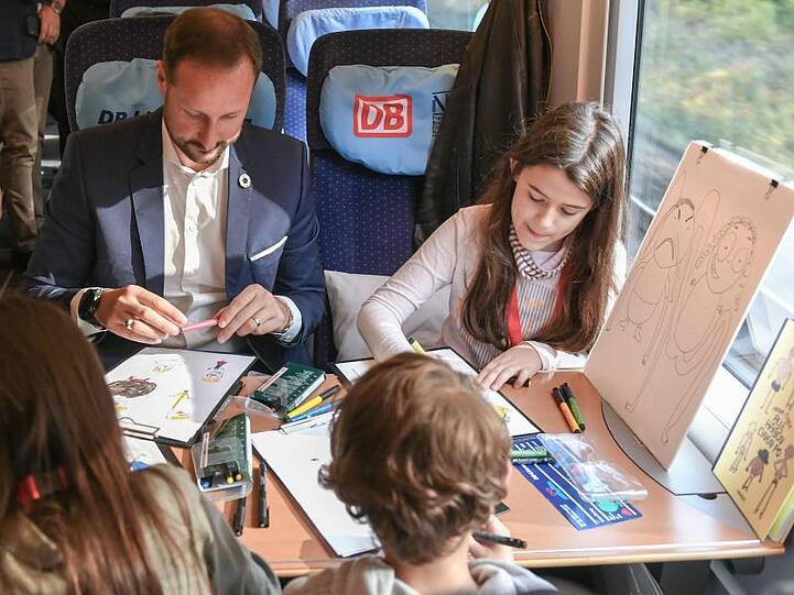 Haakon, Kronprinz von Norwegen, malt mit Kindern im Literaturzug auf dem Weg von Berlin nach Köln.