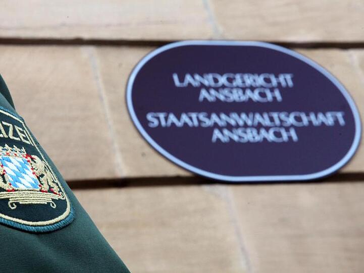Ein Polizist steht vor dem Landgericht Ansbach. Foto: Daniel Karmann/Archiv