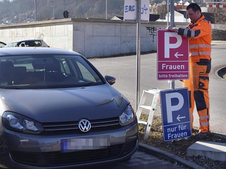 Ein Mitarbeiter der Stadt montiert an einem Parkplatz ein neues, pinkfarbenes Verkehrsschild. Foto: Tina Steimle/Archiv