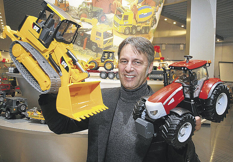 Paul Heinz Bruder mit zwei Spielwarenmesse-Neuheiten, einem Kettenlader und einem Traktor. Für den US-Truck (li.) gab es im letzten Jahr eine Auszeichnung.