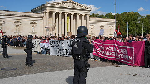 Demo und Gegendemo am Samstag am K&ouml;nigsplatz in M&uuml;nchen - die Polizei h&auml;lt die Lager auseinander. Dort forderten rund 350 Demonstranten mit Deutschlandfahnen "Diese Regierung muss weg." Angemeldet war die Veranstaltung urspr&uuml;nglich f&uuml;r bis zu 1000 Teilnehmer. Laut Polizei versammelten sich in direkter N&auml;he rund 100 Gegendemonstranten. An der Pr&uuml;f-Demo im Bereich des Siegestors nahmen nach Angaben der Polizei rund 12.000 Menschen teil &ndash; viermal so viele wie urspr&uuml;nglich angemeldet.