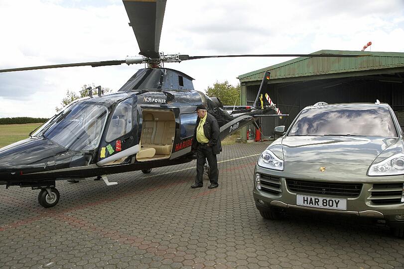 Ein überzeugter Lebemann: Haribo-Chef Hans Riegel neben seinem Hubschrauber und Porsche auf dem Golfplatz Jakobsberg in der Nähe von Koblenz.