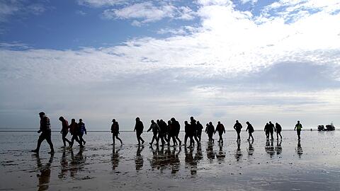 Mutmaßliche Migranten bei Dungeness, nachdem sie nach einem Zwischenfall mit einem kleinen Boot im Ärmelkanal mit einem Rettungsboot der Royal National Lifeboat Institution (RNLI) an Land gebracht wurden.
