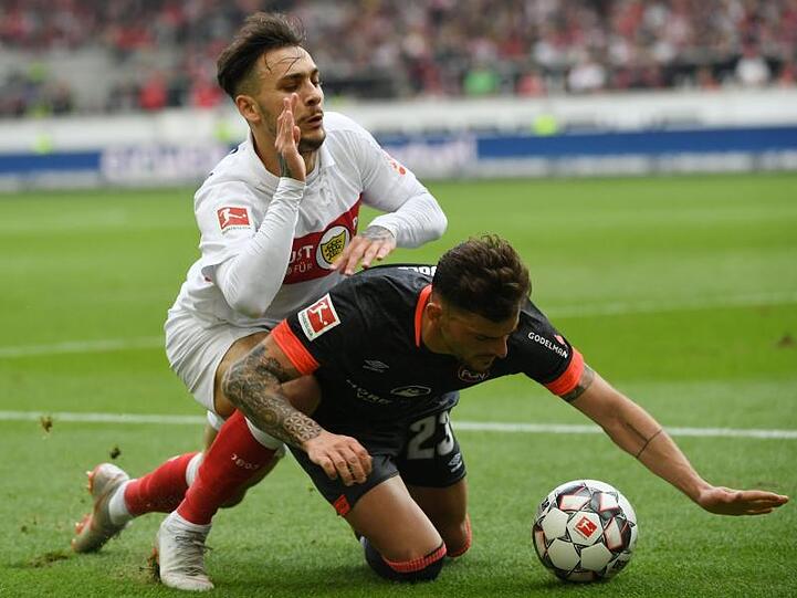 Stuttgarts Anastasios Donis (l) im Zweikampf am Boden mit Nürnbergs Tim Leibold.