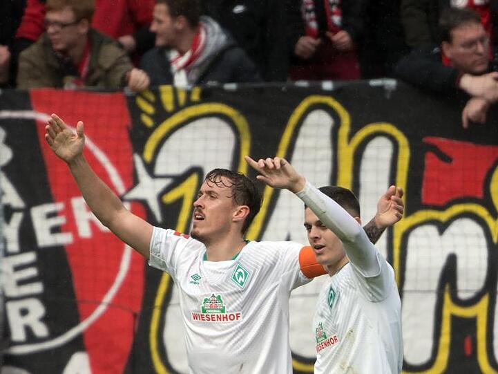 Die Bremer Torschützen Milot Rashica (r) und Max Kruse feiern den Auswärtssieg.