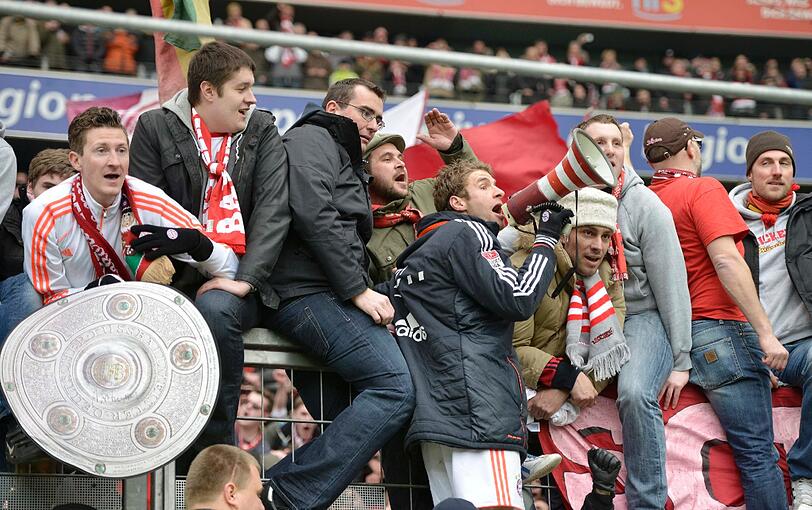 Thomas Müller feiert den Titel mit den Bayern Fans.