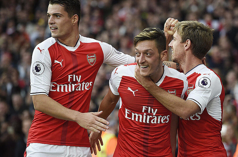 Der deutsche Nationalspieler Mesut Özil (Mitte) lässt sich von seinen Arsenal-Teamkollegen für sein Siegtor feiern.