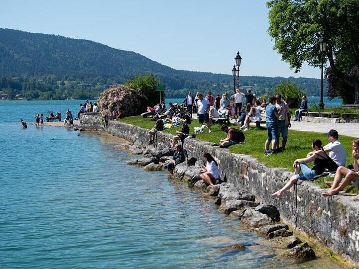 Zahlreiche Ausflügler genießen das schöne Wetter am Ufer des Tegernsees in Bayern.
