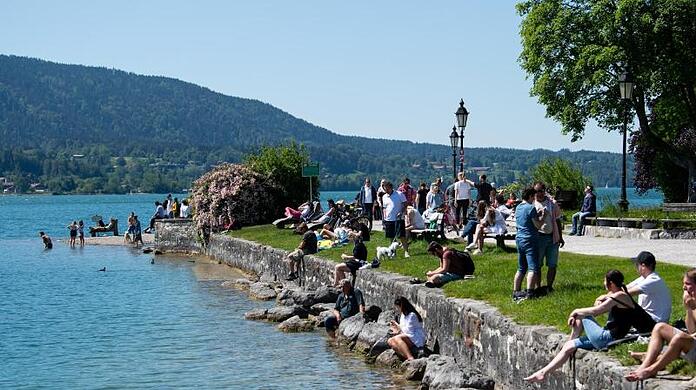 Zahlreiche Ausflügler genießen das schöne Wetter am Ufer des Tegernsees in Bayern. (Archivbild)