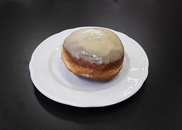 Etwas verblasst, wirkt der gr&uuml;ne Pistazienkrapfen.