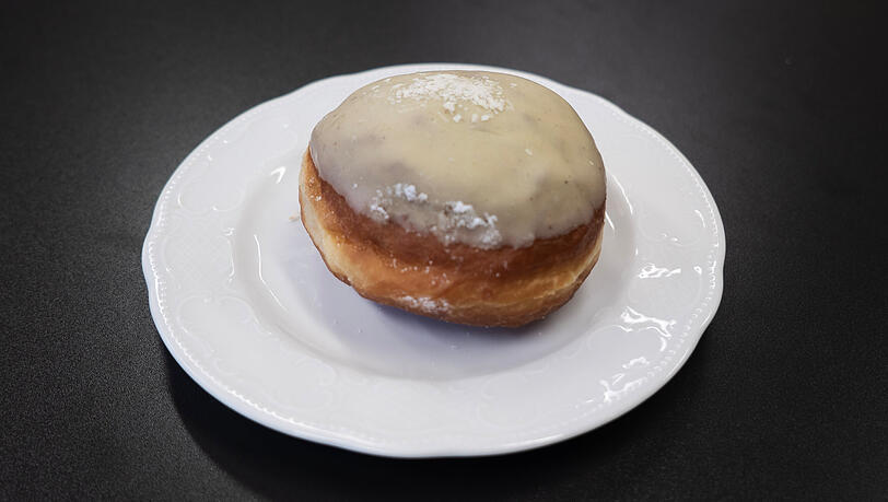 Etwas verblasst, wirkt der gr&uuml;ne Pistazienkrapfen.