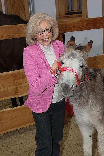 Große Tierfreundin: Show-Legende Bibi Johns, die partout nicht älter wird, streichelt einen Esel.