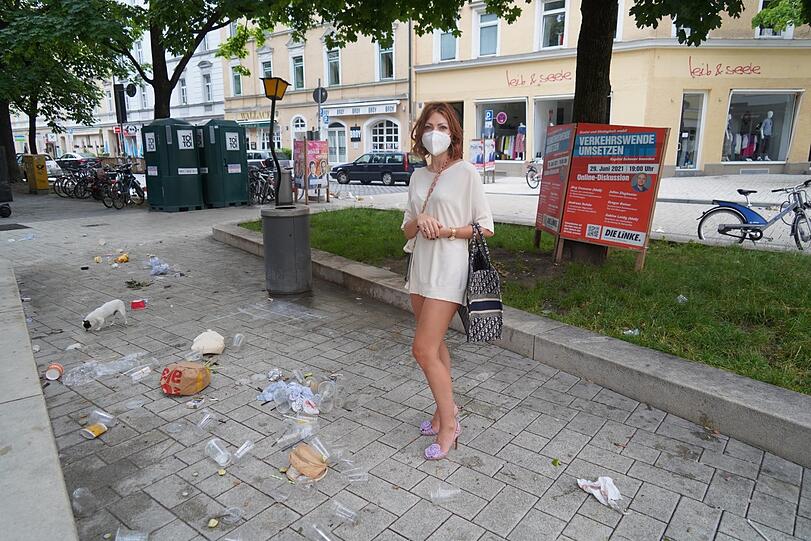 Musikerin Olesia Sandbaek steht vor einem Haufen Müll am Boden.