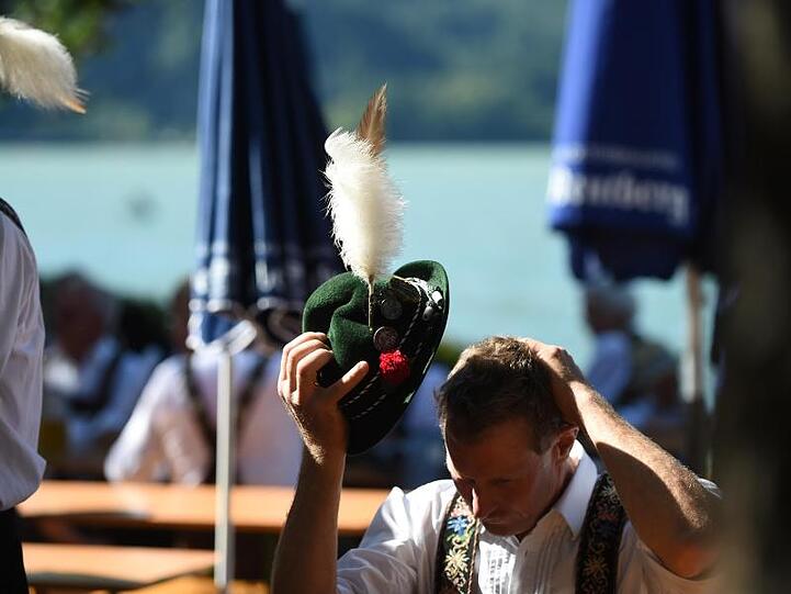 Ein Mann in Tracht sitzt in Kochel am See. Foto: picture alliance / Andreas Gebert/dpa/Archivbild