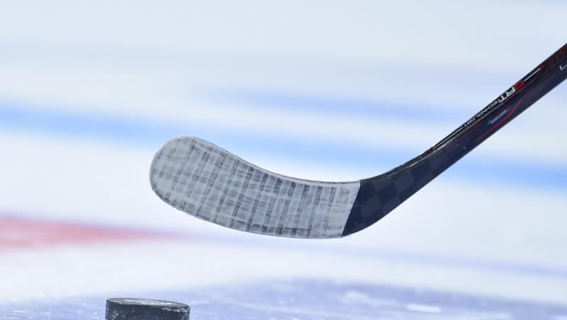 Puck und Schläger bei einem Eishockey-Spiel.