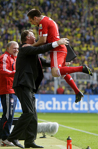 Da stürmt Franck Ribéry über das Feld, nimmt mächtig Anlauf und hüpft auf Trainer Louis van Gaal, der sich nur schwer auf den Beinen halten kann.