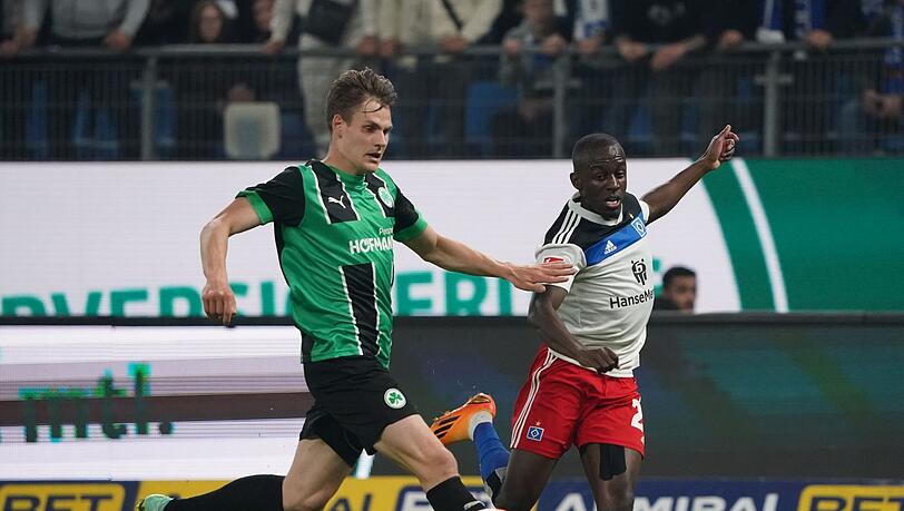 Fürths Max Christiansen (l) und Hamburgs Jean-Luc Dompe kämpfen um den Ball.
