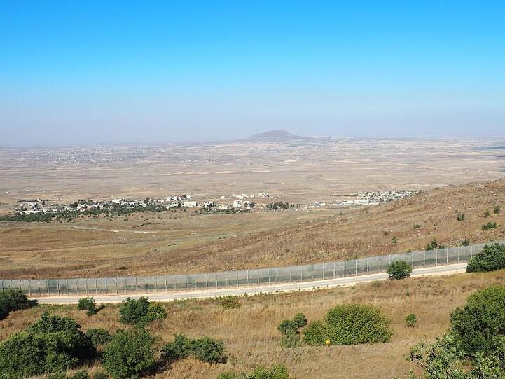 Blick von einem Hügel der Golanhöhen über den Grenzzaun nach Syrien und den Ort Birajam mit rund einem Dutzend Zelten von syrischen Flüchtlingen.