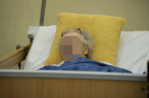 Der Angeklagte Rudolf U. verfolgt den Prozess von einem Krankenbett aus.