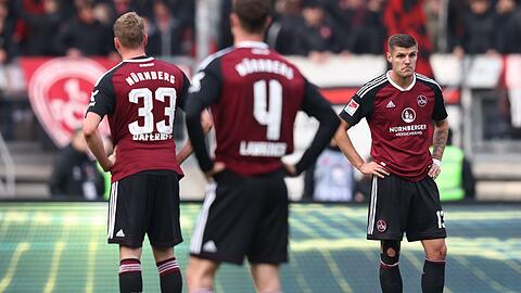 Die Nürnberger Christoph Daferner (l-r), James Lawrence und Erik Wekesser stehen nach dem Abpfiff auf dem Platz.
