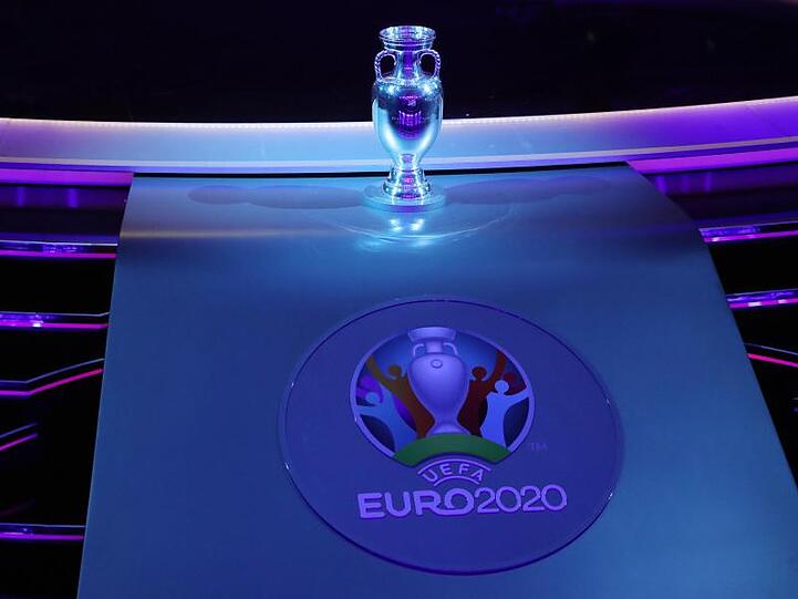 Der Henri-Delaunay-Pokal und das Logo der EM 2020. Foto: Christian Charisius/Archivbild