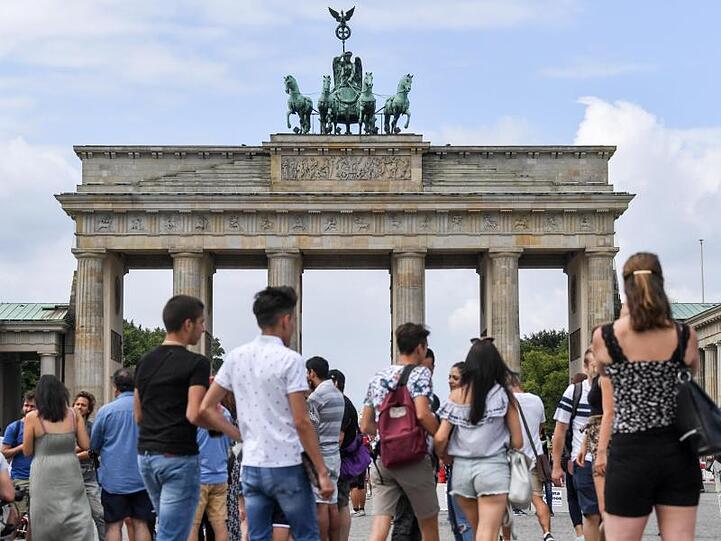 Gern besucht: Touristen stehen auf dem Pariser Platz vor dem Brandenburger Tor.