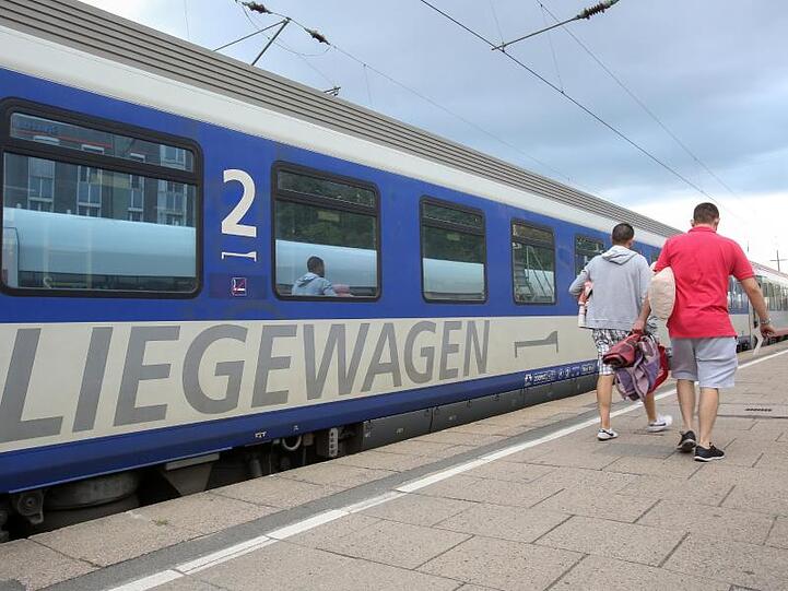 Reisende gehen zu einem Nachtzug (EuroNight) der ÖBB (Österreichische Bundesbahnen), der zur Abfahrt nach Wien im Bahnhof Altona bereit steht.