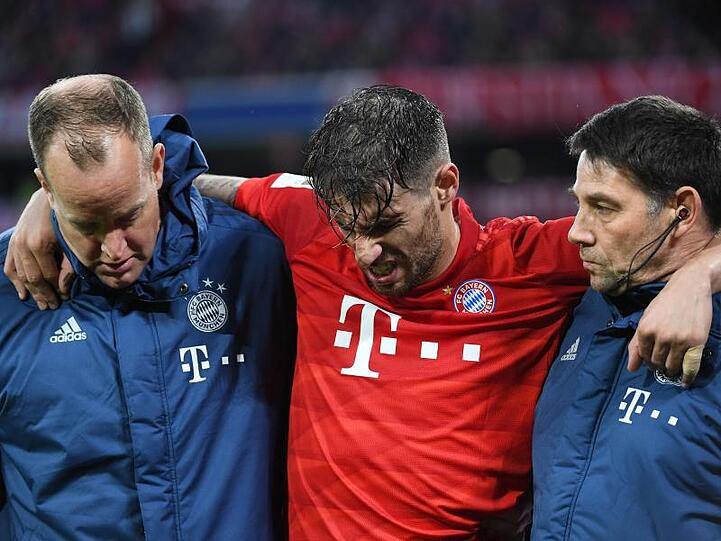 Münchens Javi Martínez (M.) wird beim Spiel gegen Wolfsburg verletzt vom Platz gebracht. Foto: Angelika Warmuth/dpa