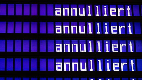 Die Worte "annulliert" sind am Flughafen München auf einer Anzeigetafel zu sehen.