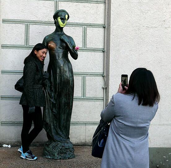 Vandalismus an der "bezaubernden Julia". Diese asiatischen Touristen lassen sich durch den gelben Farbstreifen nicht von einem Erinnerungsfoto abhalten.