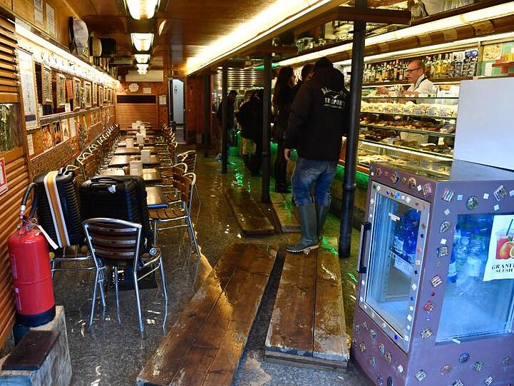 Kunden stehen an einem Tresen in einem Café. Geschäftsleute sollen nun Soforthilfen von 20.000 Euro erhalten.